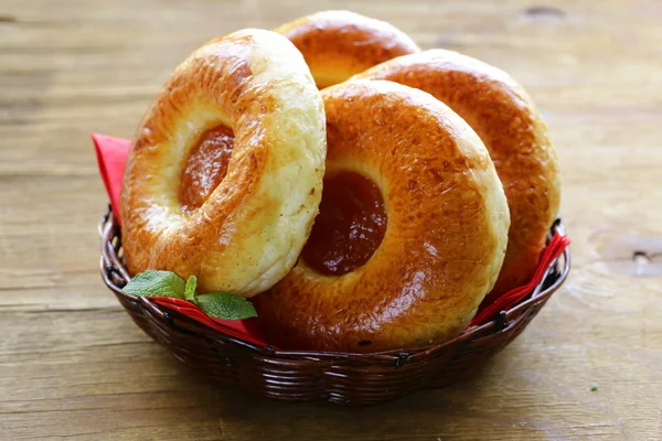 Bollos dulces redondos con mermelada de manzana en una canasta de mimbre — Foto de Stock