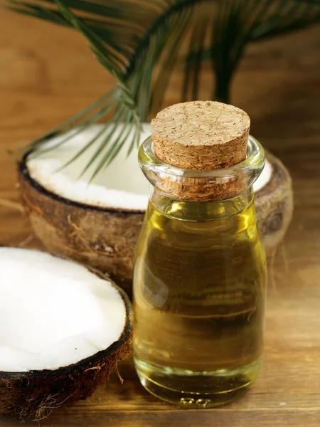 Coconut oil in a glass bottle and fresh nuts — Stock Photo, Image