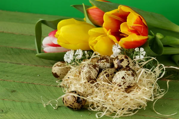 Пасхальный натюрморт с весенними цветами тюльпаны и яйца на деревянном фоне — стоковое фото