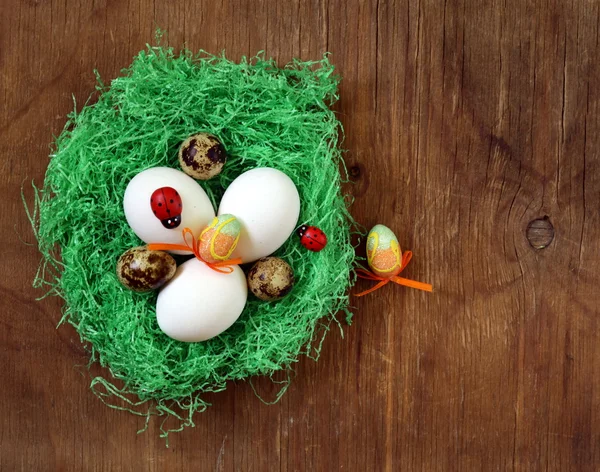 Naturaleza muerta de Pascua con flores de primavera tulipanes y huevos sobre un fondo de madera — Foto de Stock