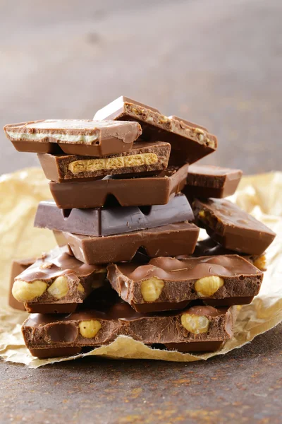 Stapel bars stukken van chocolade met verschillende smaken — Stockfoto