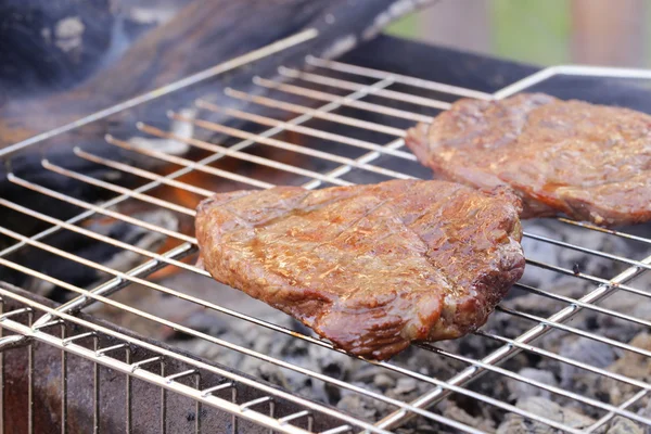 Steak de boeuf grillé sur un barbecue en plein air — Photo