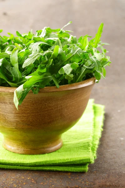 Fresh green salad arugula in a wooden bowl — Stock Photo, Image