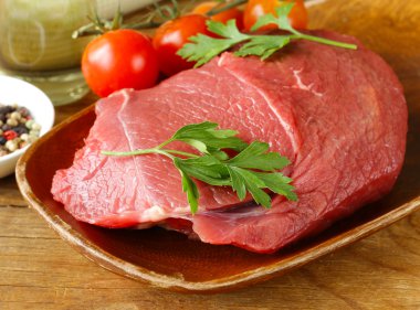 Taze çiğ Dana etli biber ve ahşap plaka üzerinde otlar