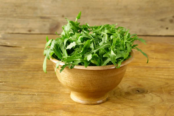 Fresh green salad arugula in a wooden bowl — Stock Photo, Image