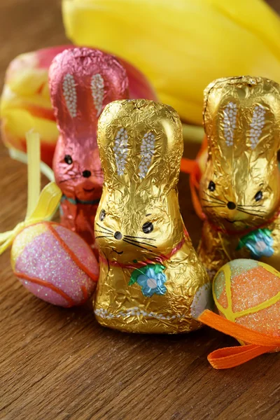 Chocolate Easter bunny candy (sweets) with tulips — Stock Photo, Image