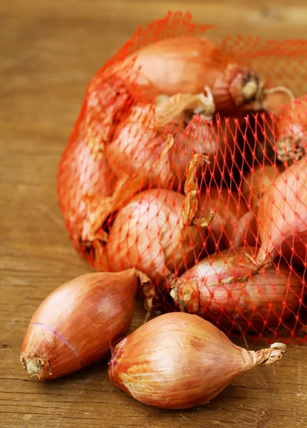 Natural organic red shallot onion on a wooden background — Stock Photo, Image