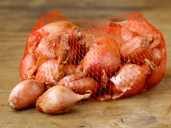 Natural organic red shallot onion on a wooden background — Stock Photo, Image