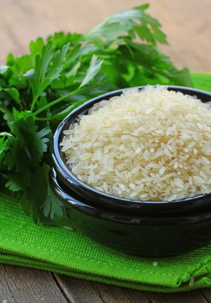 Натуральный органический белый рис в миске на деревянном фоне — стоковое фото