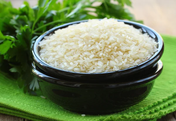 Натуральный органический белый рис в миске на деревянном фоне — стоковое фото