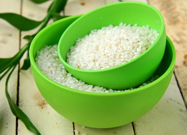 Natural organic white rice in bowl on a wooden background — Stock Photo, Image
