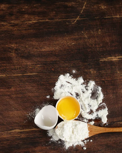 Wooden baking background with raw eggs and flour — Stock Photo, Image