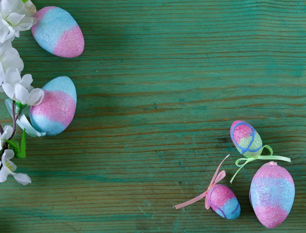 Bunte dekorative Ostereier und Zweig mit Frühlingsblumen auf altem Holzgrund — Stockfoto