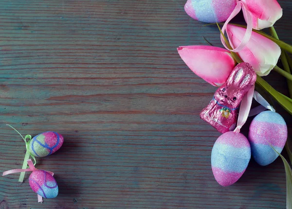Oeufs de Pâques décoratifs colorés et branche avec des fleurs de printemps sur le vieux fond en bois — Photo
