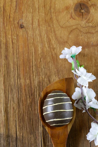 Ovos de páscoa decorativos coloridos e galho com flores de primavera no fundo de madeira velho — Fotografia de Stock