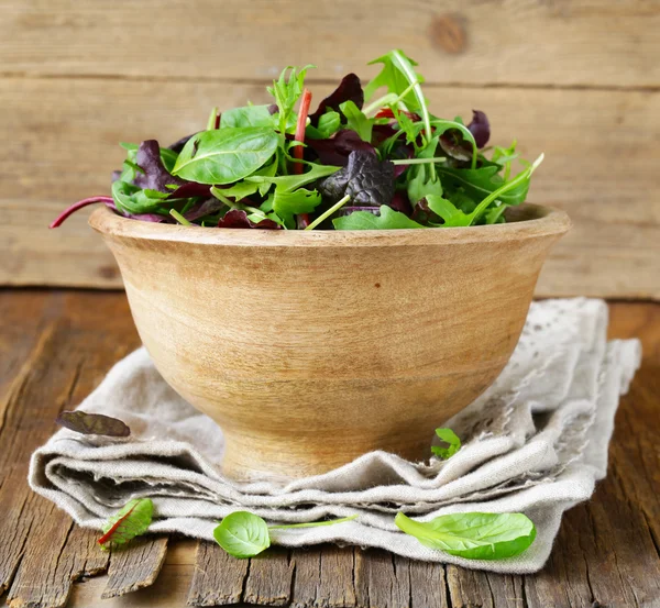 Salat (Rucola, Eisberg, Rote Bete) in einer Holzschüssel mischen — Stockfoto
