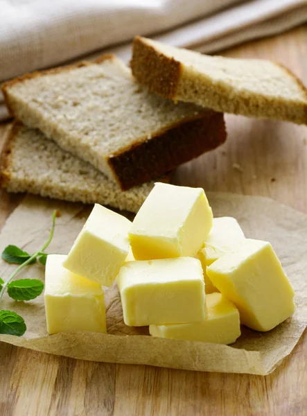 Verse gele boter geserveerd op een houten bord — Stockfoto