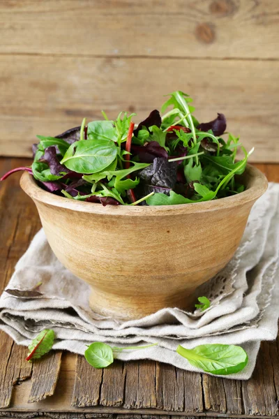 Meng salade (rucola, ijsberg, rode biet) in een houten kom — Stockfoto