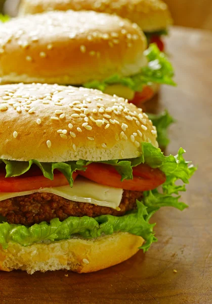 Tradiční cheeseburger s zeleným salátem a rajčaty — Stock fotografie