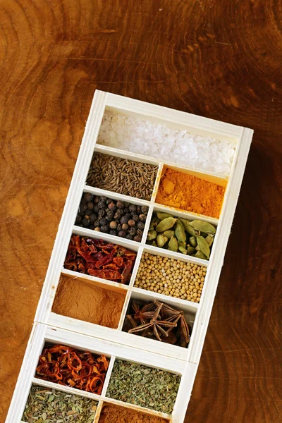 Zbiór różnych przyprawy (pieprz, sól, kurkuma, liść laurowy, chili, zioła) w drewniane pudełko — Zdjęcie stockowe