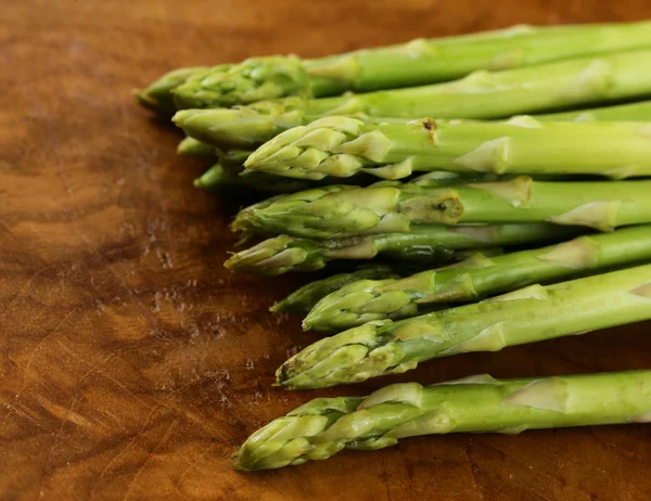 Verse groene asperges - voorjaar plantaardige op een houten achtergrond — Stockfoto