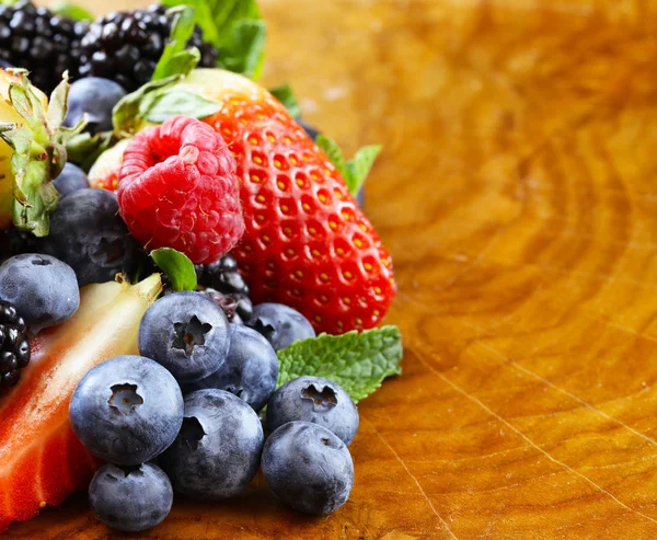 Beerensortiment - Himbeeren, Brombeeren, Erdbeeren, Blaubeeren auf hölzernem Hintergrund — Stockfoto