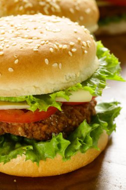 Yeşil salata ve domates ahşap arka plan üzerinde geleneksel çizburger