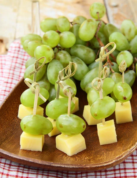 Canape snack - cheese with green grapes on wooden skewers — Stock Photo, Image