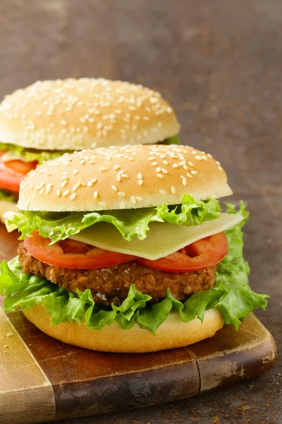 Tradiční cheeseburger s zeleným salátem a rajčaty — Stock fotografie
