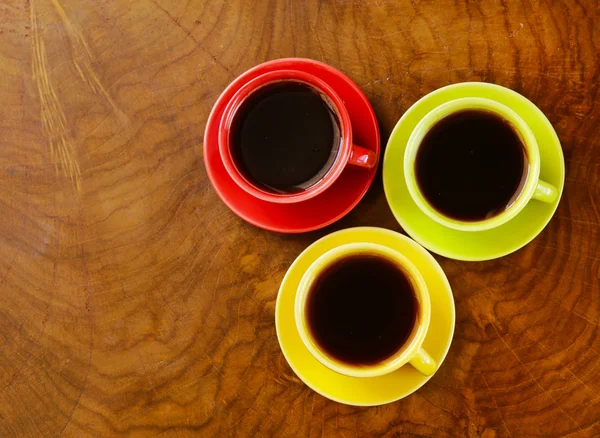 Färgglada kaffekoppar på trä bakgrund — Stockfoto