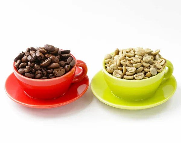 Green and black coffee beans in cup on a white background — Stock Photo, Image