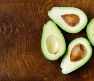 Olgun organik avokado ahşap arka plan üzerinde ikiye böldüm