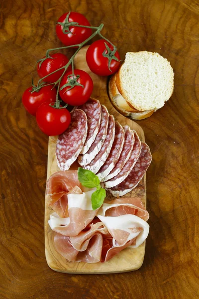 Parma ham (jamon) and delicacy smoked sausage (salami) on a wooden board — Stock Photo, Image