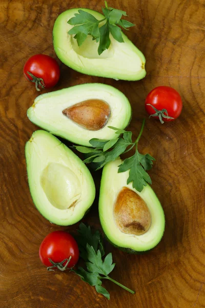 Reife Bio-Avocado halbiert auf einem hölzernen Hintergrund — Stockfoto
