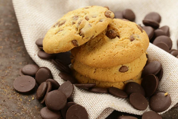 Biscoitos saborosos doces com chips de chocolate na mesa — Fotografia de Stock