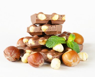 Beyaz bir arka plan üzerinde çikolata fındık ve nane yaprakları