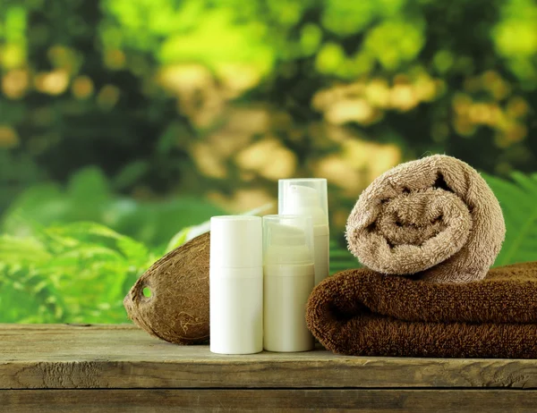 Spa concept - towels and body cream on natural green background — Stock Photo, Image