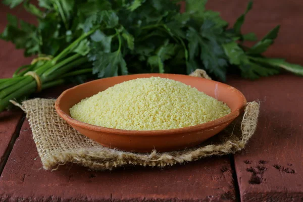 Cous cous obilovin v hliněné misky na dřevěný stůl — Stock fotografie