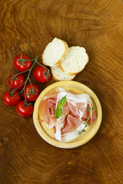 Parma ham (jamon) with fragrant herbs traditional Italian meat appetizer — Stock Photo, Image