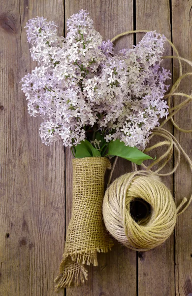 Rami di lillà in fiore su un vecchio sfondo di legno — Foto Stock