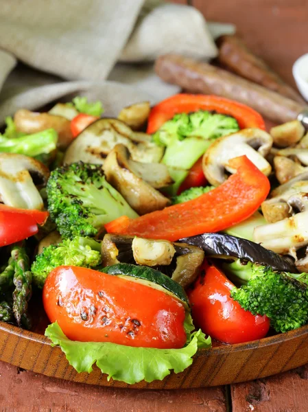 Gegrilltes Gemüse (Paprika, Spargel, Pilze, Brokkoli) in einem Holzteller — Stockfoto