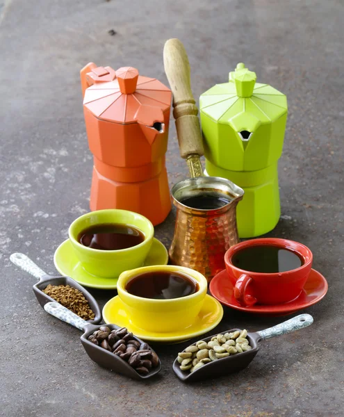 Green, black coffee beans and different utensils for boiling coffee (grinder, kettle, cezve) — Stock Photo, Image