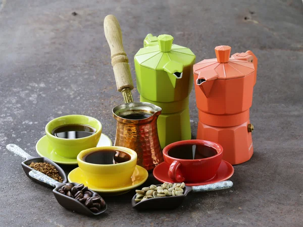 Chicchi di caffè verde, nero e diversi utensili per il caffè bollente (macinino, bollitore, cezve ) — Foto Stock