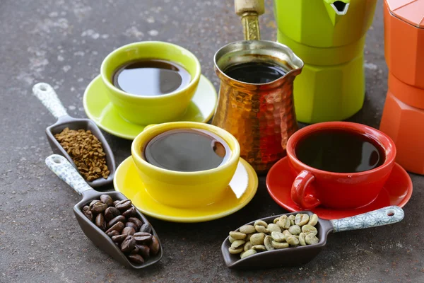 Grüne, schwarze Kaffeebohnen und verschiedene Utensilien zum Kochen von Kaffee (Mühle, Wasserkocher, Cezve)) — Stockfoto