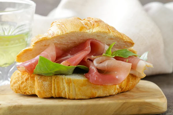 Gourmet sandwich croissant with ham and basil