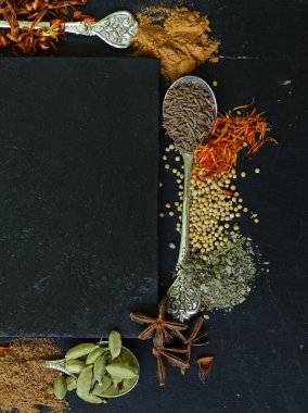 Farklı baharat (kırmızı biber, zerdeçal, biber, anason, tarçın, safran siyah bir arka plan)