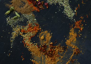 Farklı baharat (kırmızı biber, zerdeçal, biber, anason, tarçın, safran siyah bir arka plan)