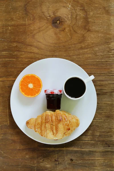 Breakfast serving funny face on the plate (jam, croissant, orange and coffee) — Stock Photo, Image