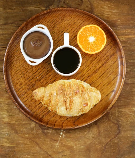 Breakfast serving funny face on the plate (croissant, chocolate spread, orange and coffee) — Stock Photo, Image