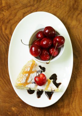 pudra şekeri ve beyaz tabakta kiraz ile ev yapımı cheesecake